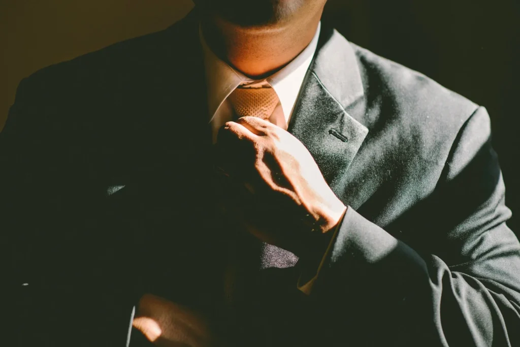 Man in a suit adjusting his tie